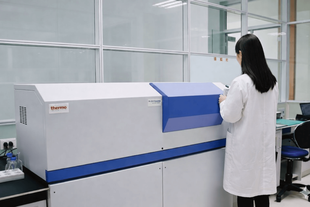 Laboratory technician operating a materials testing instrument in a quality control lab environment