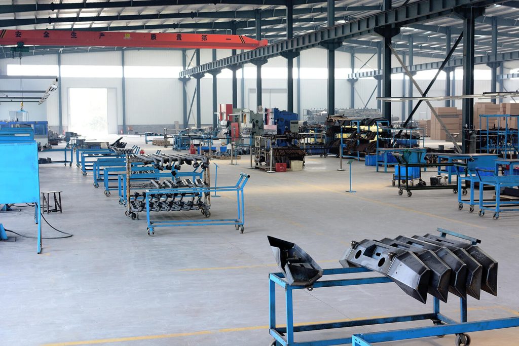 Heavy-duty truck accessory manufacturing workshop with welded steel components and assembly stations