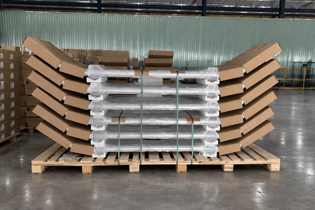 Palletized heavy-duty truck bumpers secured with protective wrapping and carton supports inside the warehouse