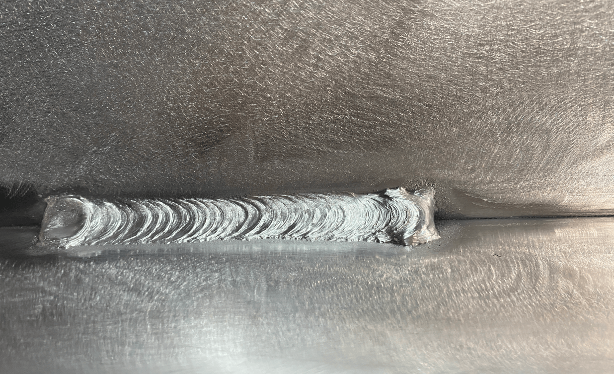 Close-up of precision TIG welding seam on heavy-duty aluminum structural component with clean, uniform weld beads