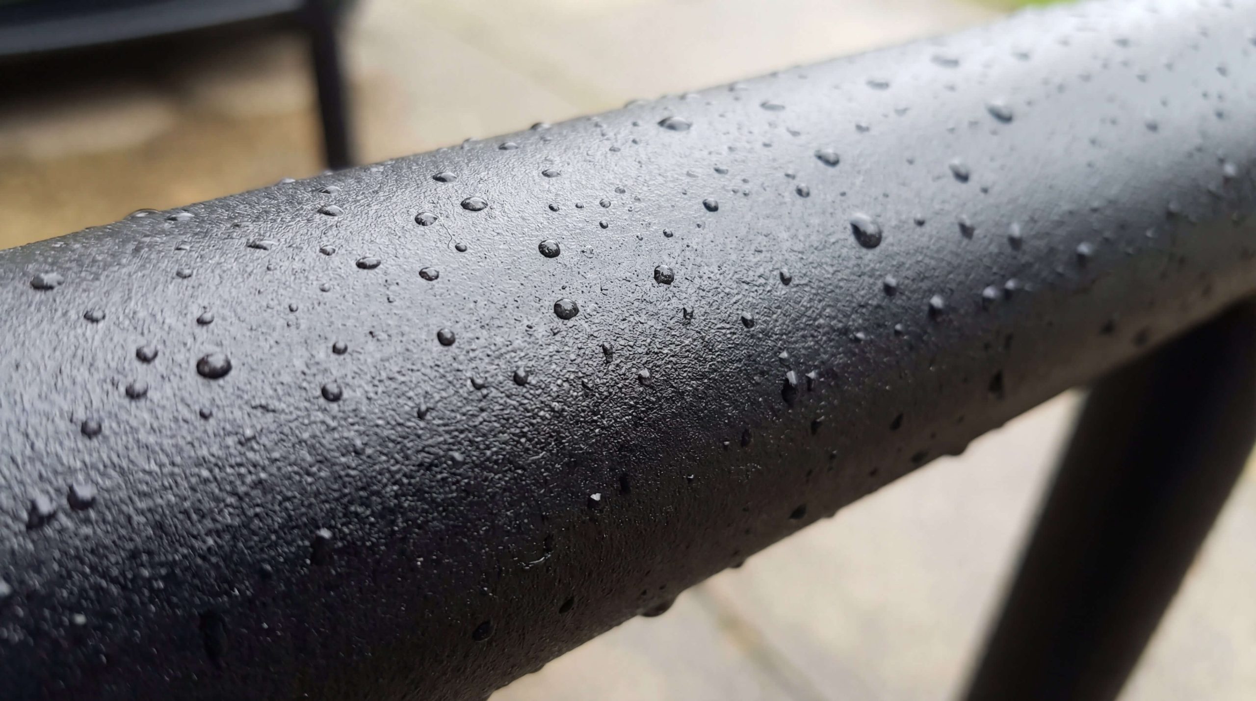Textured black powder-coated steel surface with water-repellent protective coating