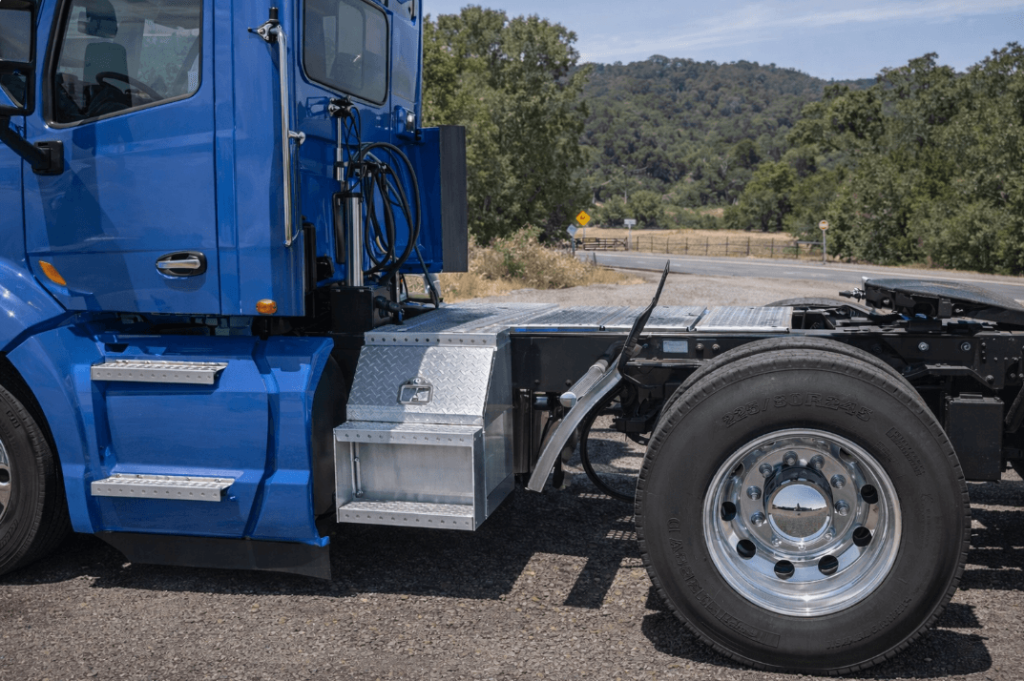 Class 8 aluminum tool storage step box mounted on a semi truck frame beside the cab and fuel tank